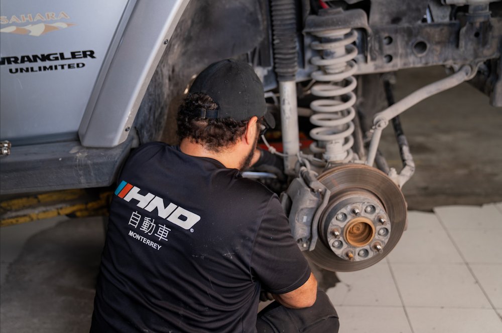 Mecánico HND realizando mantenimiento de suspensión